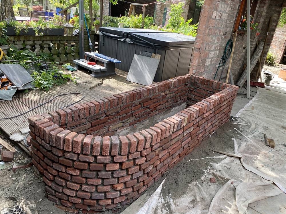 Gemetselde plantenbak van hergebruikte oude bakstenen met staande rollaag
