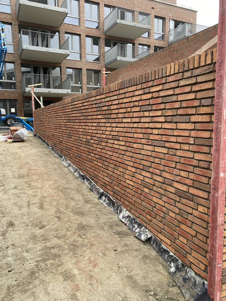 Lange gemetselde erfafscheiding bij nieuwbouwappartementen